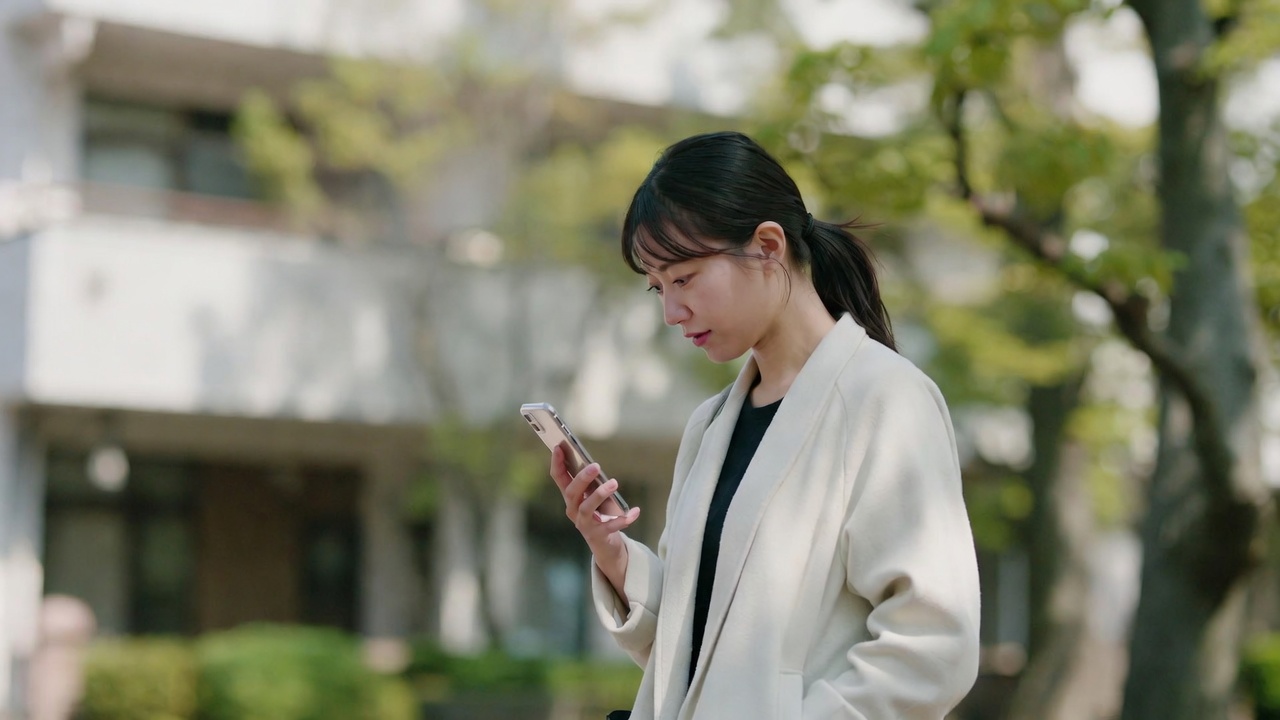スマートフォンで問い合わせを確認する女性
